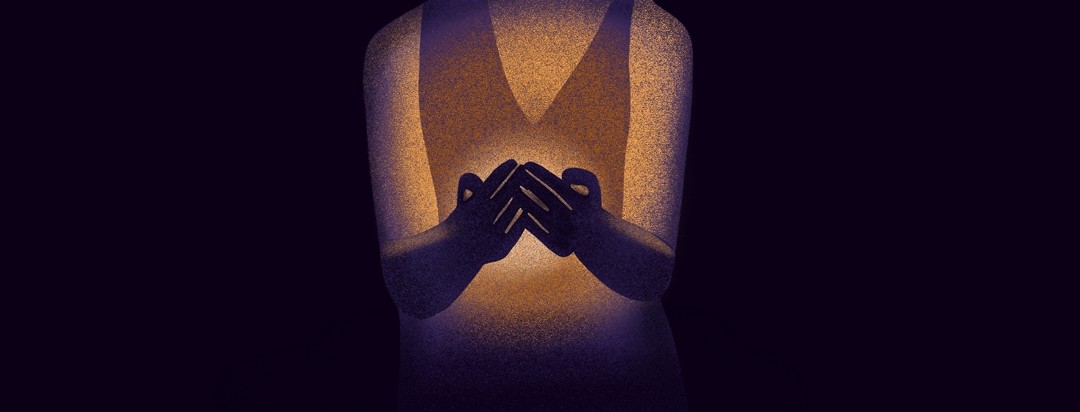 A woman holds a light in her hands in a dark room