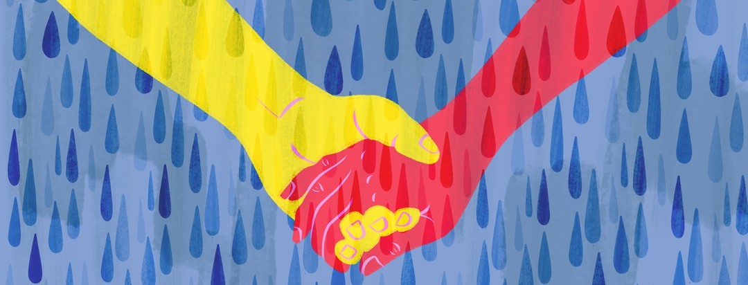 Two hands holding in the middle of a rain shower