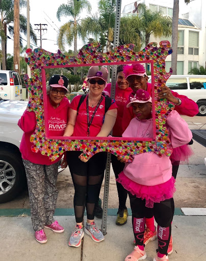 4 friends posing in a frame at a breast cancer event