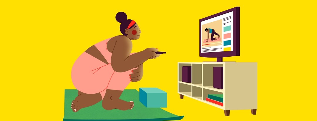 A woman crouches over a yoga mat, holding a TV remote as she chooses a yoga YouTube tutorial to watch on her TV, which is sitting on a TV stand in front of her