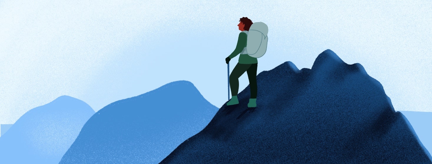 A woman climbs the third mountain in a mountain range