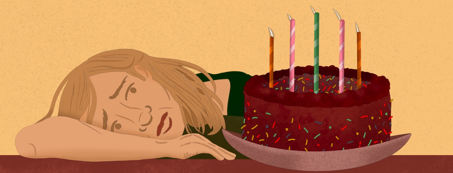 Person lays head on table looking worriedly at birthday cake with candles