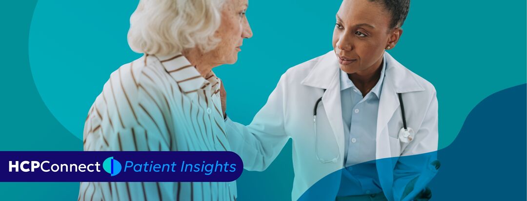 A doctor sits with a patient with her arm on her shoulder